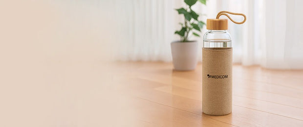 Die Medicom Trinkflasche und Kollagen Peptide auf enem Holztablet